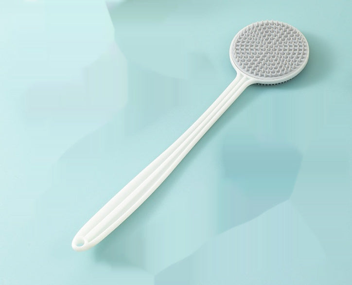 Gray long-handle silicone back massage brush on a lifestyle background